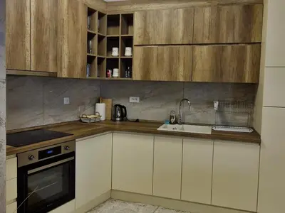 a kitchen with wooden cabinets and a sink at Gracia apartman in Vrnjci