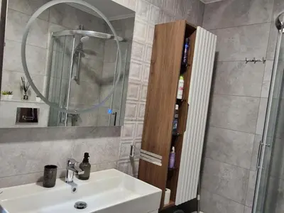 a bathroom with a sink and a shower with a mirror at Gracia apartman in Vrnjci