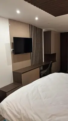 a bedroom with a bed and a desk with a television at SkyNest 605 Apartment in Kopaonik