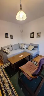 a living room with a blue couch and a table at Apartment 4 in Niš