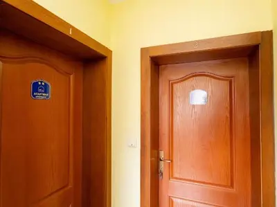 two wooden doors in a room with a sign on it at Apartmani Votor in Vrnjačka Banja