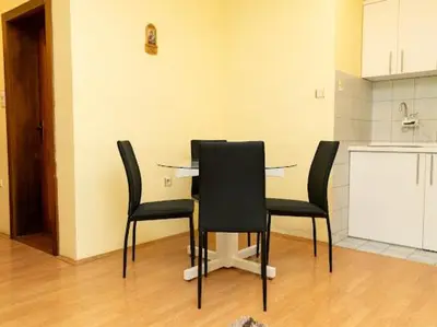 a table with black chairs in a kitchen at Apartmani Votor in Vrnjačka Banja