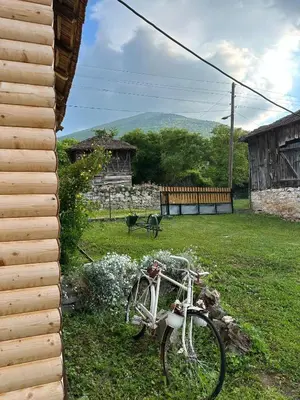 a bike parked in the grass next to a house at Primo apartmani in Mirovo