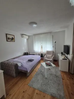 a bedroom with a bed and a chair and a table at Studio VA2016 in Kruševac