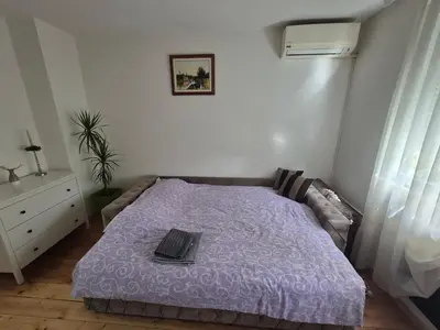 a bedroom with a purple bed with a laptop on it at Studio VA2016 in Kruševac