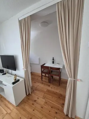 a living room with a table and a curtain at Studio VA2016 in Kruševac