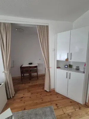 an empty living room with a table and curtains at Studio VA2016 in Kruševac