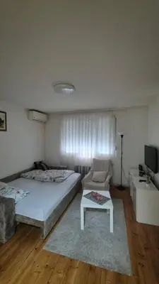 a bedroom with a bed and a couch and a table at Studio VA2016 in Kruševac
