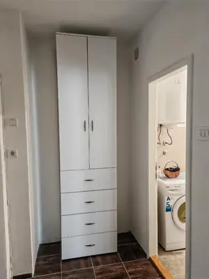 a white cabinet in a bathroom with a washing machine at Apartman-Stan in Jagodina