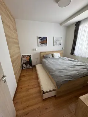 a bedroom with a bed with a bench in it at Apartman Vila Jaram, Kopaonik in Kopaonik