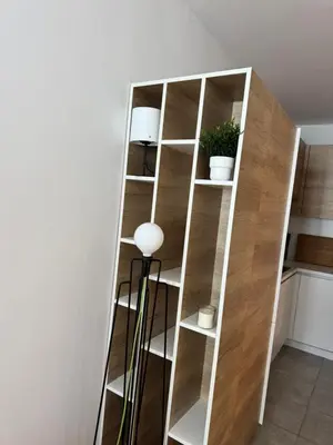 a wooden book shelf in a room with a lamp at Apartman Vila Jaram, Kopaonik in Kopaonik
