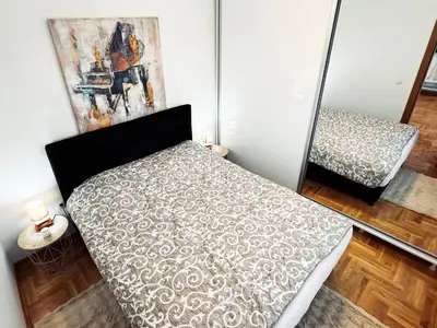 a bedroom with a bed and a painting on the wall at Azure in Vrnjačka Banja
