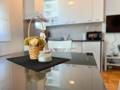 a table with a basket of flowers on a kitchen counter at Azure in Vrnjačka Banja