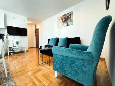 a living room with a blue couch and a table at Azure in Vrnjačka Banja