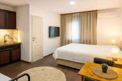 a hotel room with a bed and a table at Garden Lux Grujić Apartmani in Krivi Vir