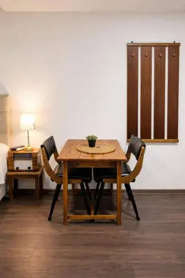 a dining room table with two chairs and a bed at Garden Lux Grujić Apartmani in Krivi Vir