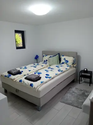 a bed sitting in a bedroom with a white wall at Sofora