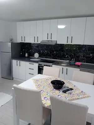 a kitchen with a table with white cabinets and a table and chairs at Sofora