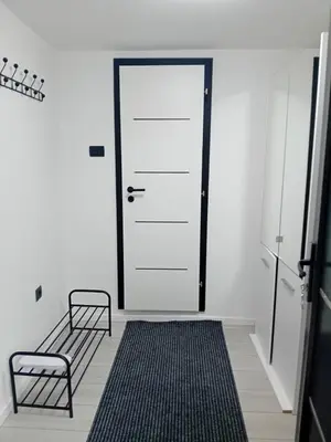 a room with a door and a bench and a rug at Sofora