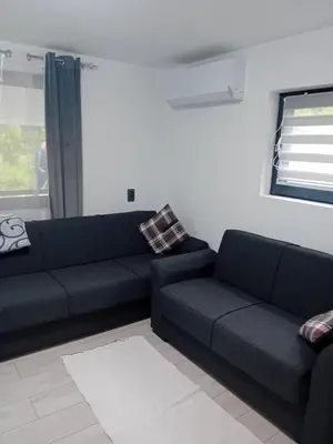 a black couch in a living room with a window at Sofora