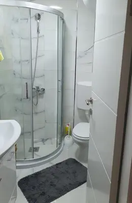 a bathroom with a shower and a toilet and a sink at Apartman Orhideja in Knjazevac.