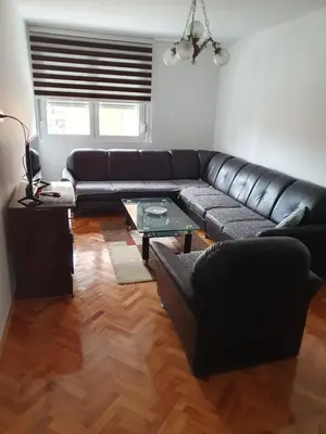 a black leather couch in a living room at Apartman Orhideja in Knjazevac.