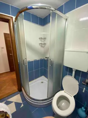 a bathroom with a shower with a toilet and a basketball hoop at Apartman Katić in Vrnjačka Banja