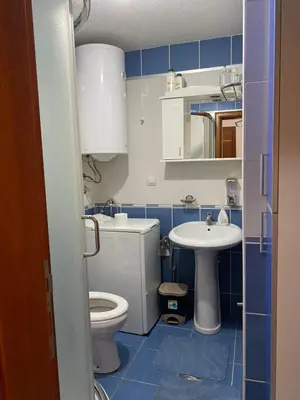 a blue and white bathroom with a toilet and a sink at Apartman Katić in Vrnjačka Banja
