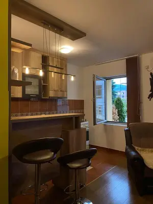 a kitchen with two bar stools and a window at Apartman Katić in Vrnjačka Banja