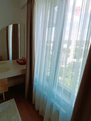 a bathroom with a window with white curtains and a sink at LanDan Planet - free parking in Niš
