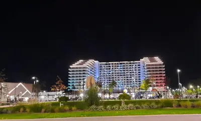 a large building with lights on it at night at LanDan Planet - free parking in Niš