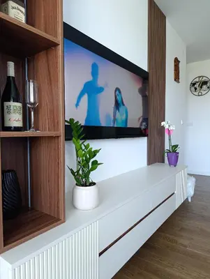 a living room with a tv on a wall at LanDan Planet - free parking in Niš