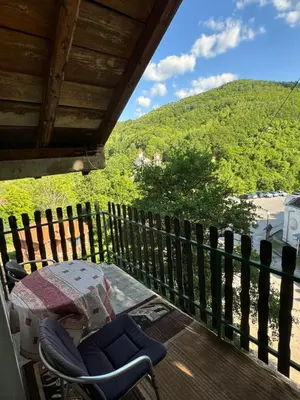 a porch with a chair and a view of a beach at Apartmani Rada in Prolomska Banja
