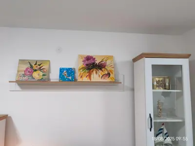 a shelf with three paintings on top of a wall at You See Gold app in Pojate