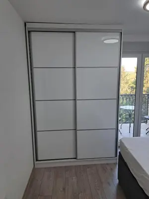 a bedroom with a white closet with a glass door at You See Gold app in Pojate