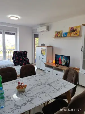 a living room with a table and chairs and a tv at You See Gold app in Pojate