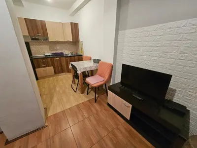 a living room with a television and a table with chairs at Apartman K&M in Vranje