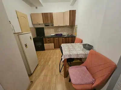 a small kitchen with a table and a refrigerator at Apartman K&M in Vranje