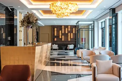 a lobby of a hotel with chairs and a bar at ZEPTERME Promenada - Šetalište in Vrnjačka Banja