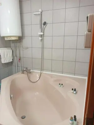 a bath tub with a shower in a bathroom at Apartmani Milica in Kraljevo