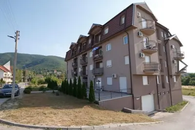 a large apartment building with a yard in front of it at Apartman Delux in Soko Banja