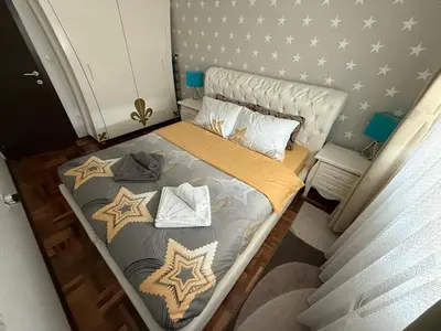 a small bedroom with a bed with stars on the wall at Apartman Delux in Soko Banja
