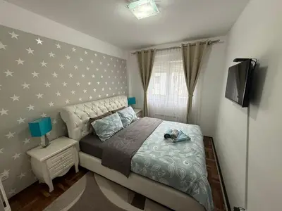 a bedroom with a bed with stars on the wall at Apartman Delux in Soko Banja