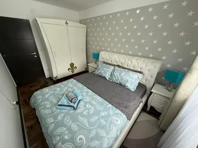 a small bedroom with a bed and a dresser at Apartman Delux in Soko Banja
