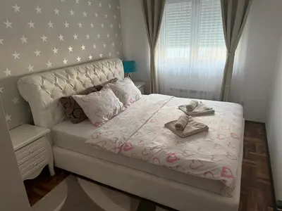 a bedroom with a bed with a cross on it at Apartman Delux in Soko Banja