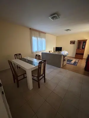 a living room with a table and chairs and a couch at Kuća Kostić in Gornja Toponica