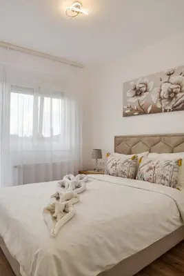 a bedroom with a large white bed with towels on it at Apartman Stevanovic in Vrnjačka Banja
