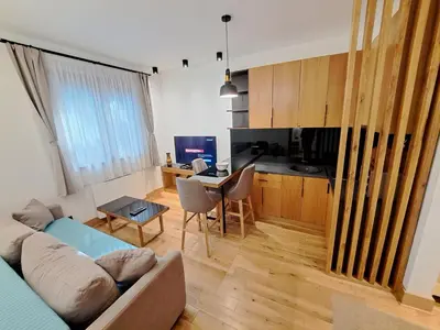 a living room with a couch and a table at Casa di legno apartman 3,6,9 in Kopaonik