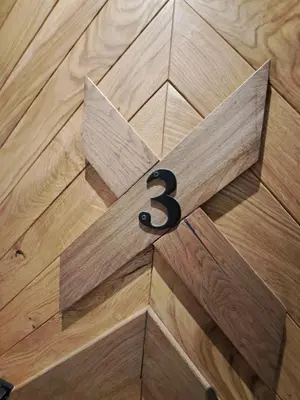 a wooden cross with the number three on a wooden floor at Casa di legno apartman 3,6,9 in Kopaonik