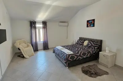 a bedroom with a bed and a chair in it at Stan na dan Crystal in Paraćin